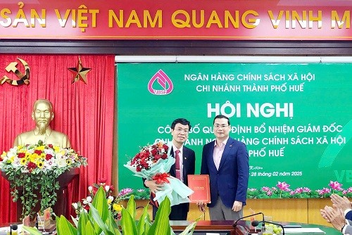 Ông Đoàn Trung Thành - Phó Tổng Giám đốc NHCSXH Việt Nam (bên phải) trao quyết định và chúc mừng ông Phan Văn Pháp.