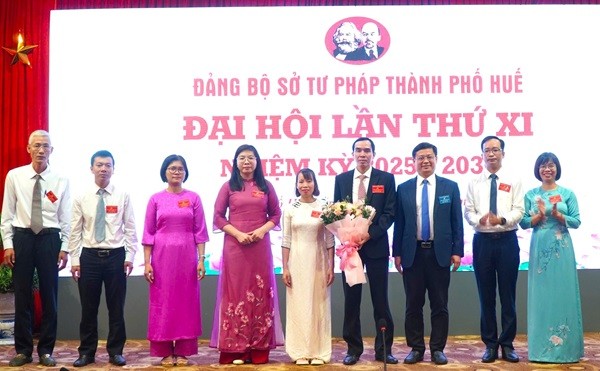Phó Chủ tịch Thường trực UBND TP Huế Nguyễn Thanh Bình (thứ 3, bên phải qua) tặng hoa chúc mừng Ban chấp hành Đảng bộ Sở Tư pháp nhiệm kỳ 2025 - 2030.