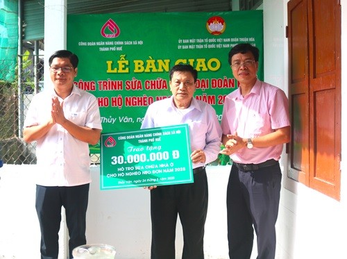 Ông Nguyễn Chí Tài - Phó Chủ tịch UBND TP Huế và Giám đốc Ngân hàng CSXH TP Huế ông Phan Văn Pháp trao tặng 30 triệu đồng hỗ trợ sửa chữa nhà cho người dân.