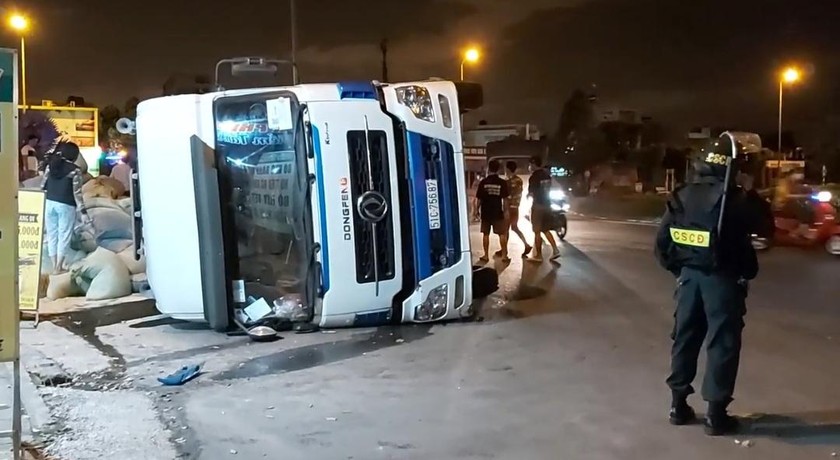 Long An: Xe đầu kéo lật ngang trên QL1A, hàng trăm bao cám đổ tràn lan xuống đường