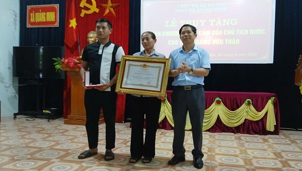 Thừa Ủy quyền của Chủ tịch nước, lãnh đạo TX. Ba Đồn trao Huân chương Dũng cảm cho thân nhân ông Hoàng Hữu Thão.