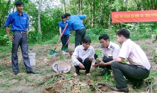 Cán bộ thi hành án giúp dân trong sản xuất.