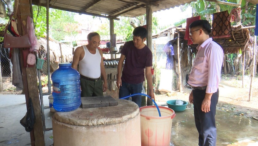 Cán bộ NHCSXH đang triển khai với người dân cho vay chương trình tín dụng nước sạch. 