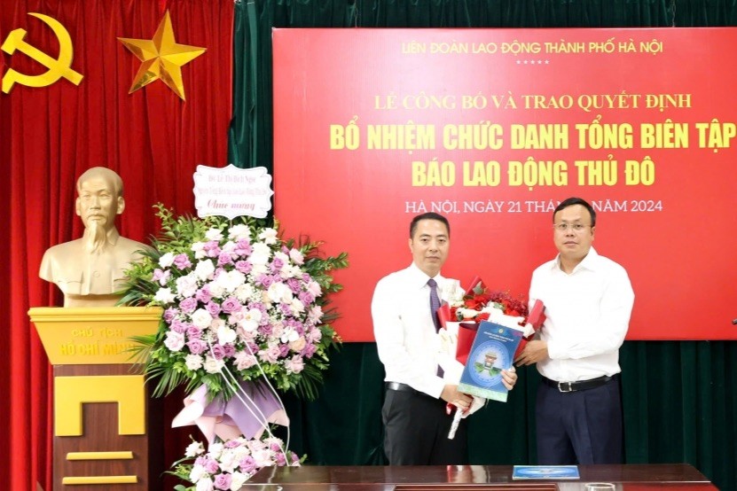 Chủ tịch LĐLĐ thành phố Hà Nội Phạm Quang Thanh trao Quyết định và hoa chúc mừng tân Tổng Biên tập Báo Lao động Thủ đô Nguyễn Văn Bình.