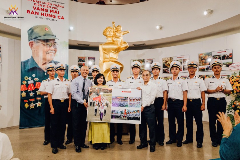 Nghệ sĩ nhiếp ảnh Nguyễn Á (người mặc sơ mi bên trái ảnh) đã trao tặng cho Bảo tàng Phụ nữ Việt Nam một số bức ảnh chụp trong lễ kỷ niệm 70 năm Chiến thắng Điện Biên Phủ. Nguồn BTPNVN