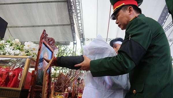 Vợ Thượng tá Lê Tất Thắng đau đớn chạm vào di ảnh chồng.