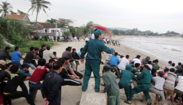 Hàng trăm ngư dân kéo tàu cá gặp nạn vào bờ