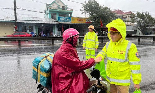 CSGT vừa trao đồ ăn, nước uống vừa tuyên truyền người dân chấp hành luật giao thông đường bộ.