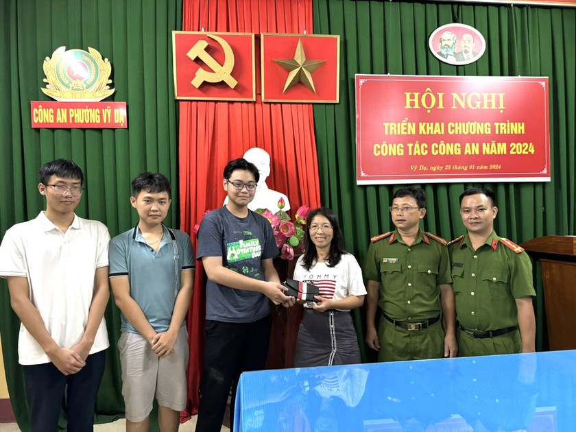 Công an phường Vỹ Dạ cùng 3 em học sinh bàn giao lại chiếc ví cho chị Hương.