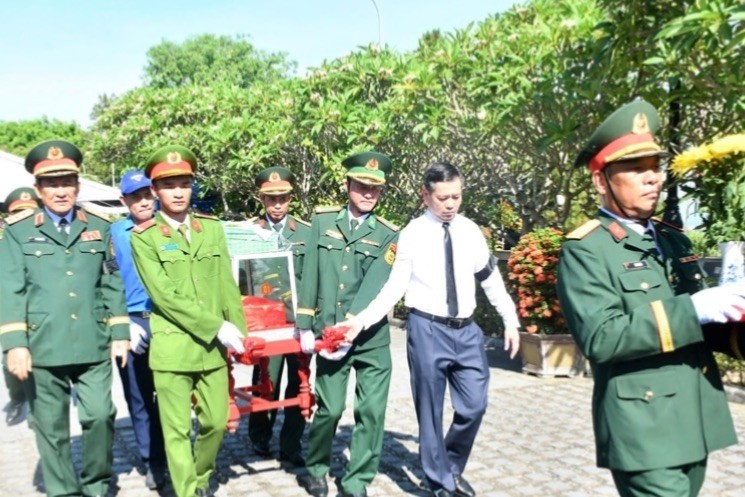 Các đại biểu di chuyển hài cốt liệt sĩ đến vị trí an táng trong nghĩa trang.