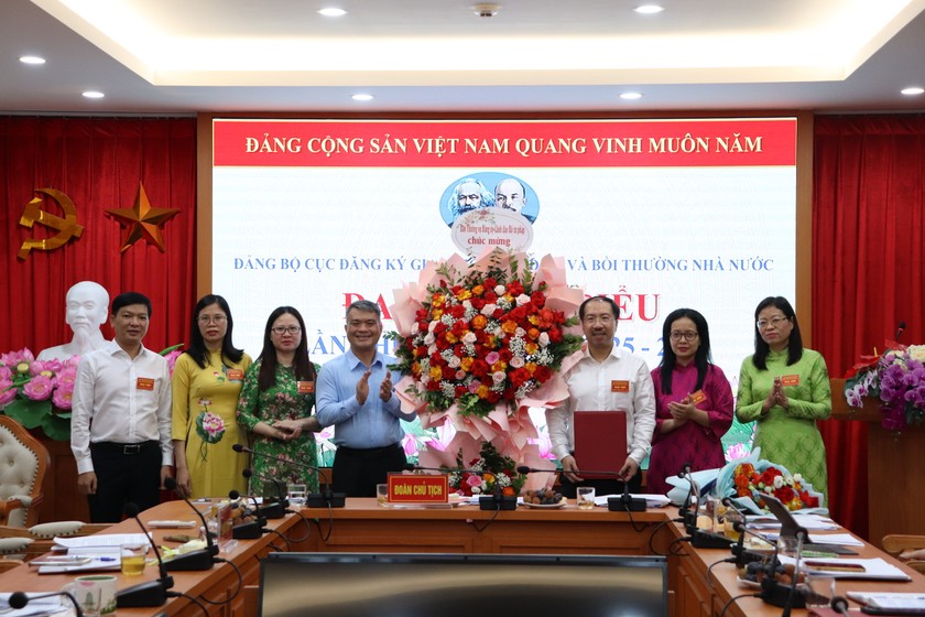 Ủy viên Ban Thường vụ Đảng ủy Bộ, Thứ trưởng Bộ Tư pháp Nguyễn Thanh Tú trao Quyết định và tặng hoa chúc mừng Ban Chấp hành Đảng bộ Cục ĐKGDBĐ&BTNN nhiệm kỳ 2025-2030.