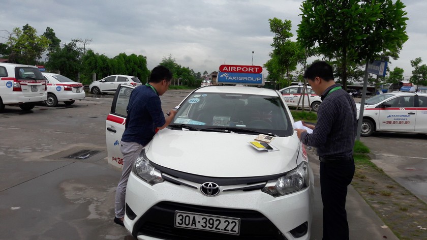 Nhân viên VETC và TAXIGROUP phối hợp dán thẻ E-tag trên kính lái để ứng dụng công nghệ thu phí không dừng