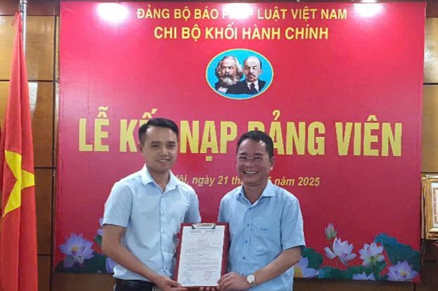 Đồng chí Vũ Hoài Nam - Bí thư Đảng ủy, Tổng Biên tập Báo Pháp luật Việt Nam trao quyết định kết nạp đảng viên cho đồng chí Lê Đình Quyết.