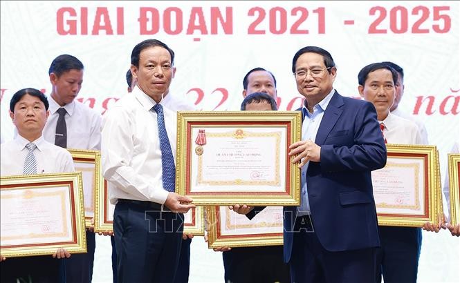 Thủ tướng Phạm Minh Chính trao Huân chương Lao động hạng Ba cho Đảng bộ, chính quyền và nhân dân huyện có thành tích xuất sắc trong Phong trào thi đua “Cả nước chung tay xây dựng nông thôn mới”. Ảnh: Dương Giang/TTXVN