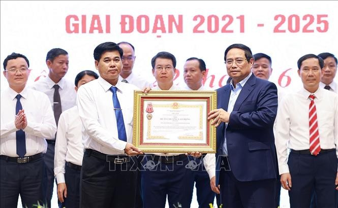Thủ tướng Phạm Minh Chính trao Huân chương Lao động hạng Ba cho Đảng bộ, chính quyền và nhân dân huyện có thành tích xuất sắc trong Phong trào thi đua “Cả nước chung tay xây dựng nông thôn mới”. Ảnh: Dương Giang/TTXVN