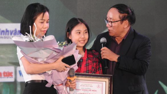 Nguyễn Vũ An Băng nhận giải thưởng Khát vọng Dế Mèn cùng mẹ - Ảnh: T.ĐIỂU