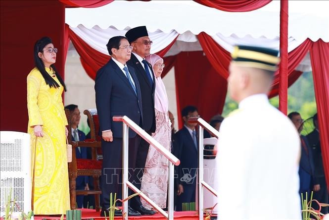 Thủ tướng Phạm Minh Chính và Thủ tướng Malaysia Anwar Ibrahim nghe quân nhạc cử Quốc thiều hai nước. Ảnh: Dương Giang/TTXVN