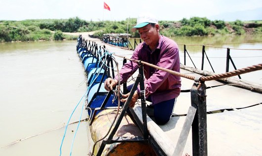 Ông Lê Tất Dũng sửa chữa, bảo dưỡng cây cầu phao