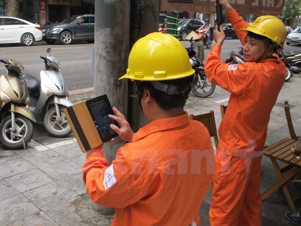 Nhân viên ngành điện ghi chỉ số côngtơ của khách hàng. Ảnh: Vietnam+