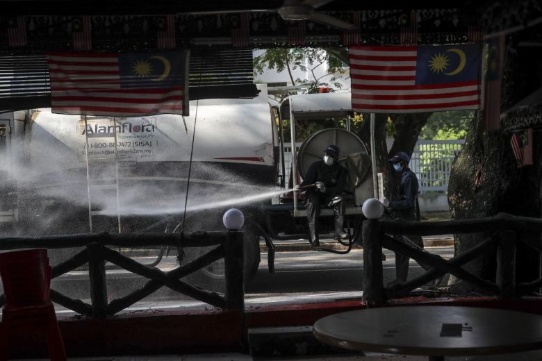 Nhân viên y tế của Tòa thị chính khử khuẩn xung quanh Nhà thờ Hồi giáo Sri Petaling ở Kuala Lumpur hôm 28/3. Ảnh: EPA-EFE