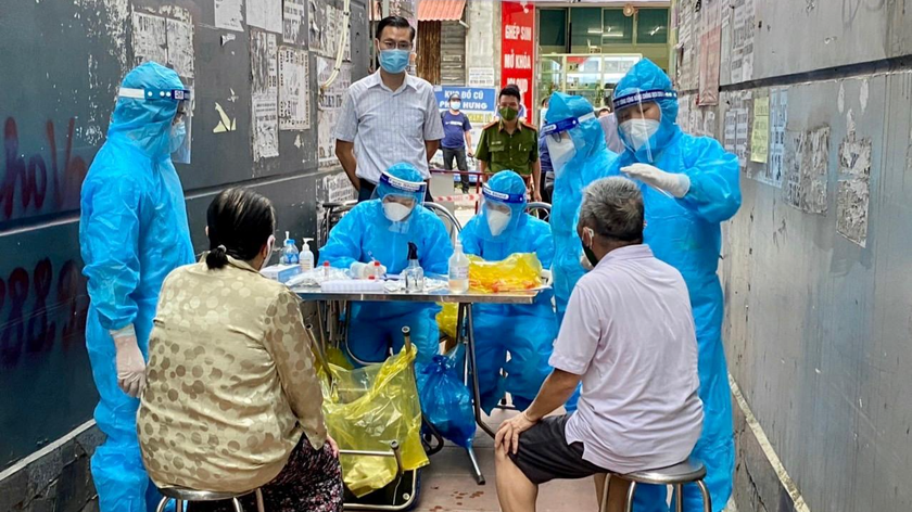 Lực lượng chức năng lấy mẫu xét nghiệm tại khu vực nhà bệnh nhân.