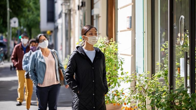 Những dân xếp hàng bên ngoài một cửa hàng thực hiện giãn cách xã hội. Ảnh: Getty Images