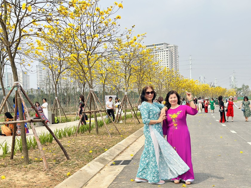 Bà Nguyễn Ngọc Thu (áo dài đỏ) và bạn thướt tha trong tà áo dài dưới hàng hoa phong linh.