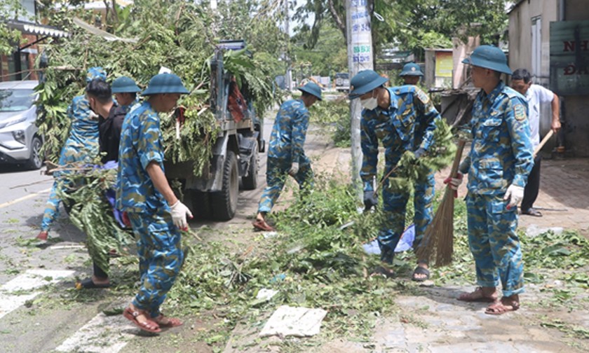 Bộ đội giúp dân dọn dẹp đường phố sau cơn bão.