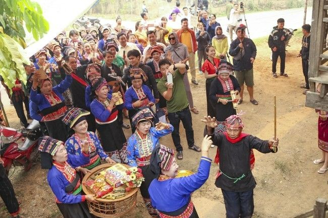 Đoàn người xin nước làm lễ só nặm phạ phốn (xin nước mưa) trước gia chủ. (Ảnh: Xuân Tư - TTXVN)