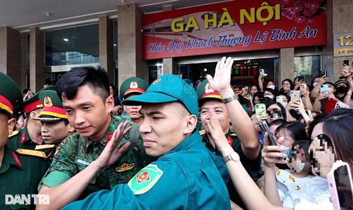 Nam quân nhân bị đám đông vây kín, hò hét, xô đẩy và lôi kéo, phải nhờ đến sự hỗ trợ của đồng đội và lực lượng dân quân tự vệ mới có thể thoát ra ngoài. (Ảnh: Phong Vũ)