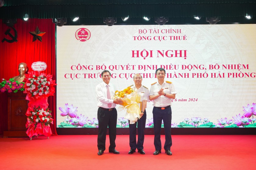 Tổng Cục trưởng Tổng cục Thuế Mai Xuân Thành và Chủ tịch UBND TP Hải Phòng Nguyễn Văn Tùng trao Quyết định, tặng hoa chúc mừng ông Nguyễn Tiến Trường. 