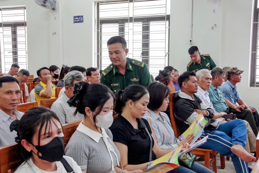 Cán bộ BĐBP phát tờ rơi tuyên truyền cho ngư dân.