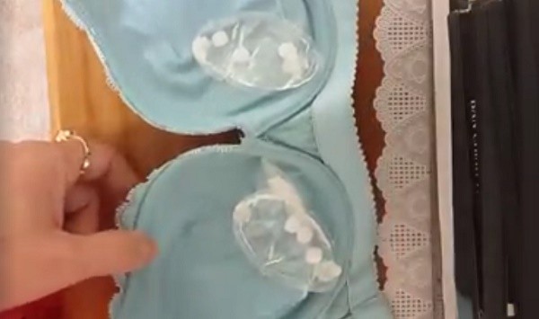 Chất lạ được lôi ra từ áo lót. (Ảnh cắt từ clip)