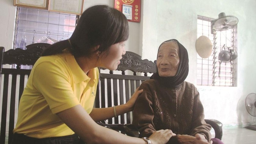 Nhân viên Bưu điện Tam Kỳ chi trả trợ cấp người có công tại nhà (ảnh chụp trước ngày 28/3).