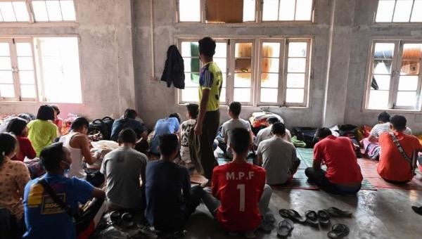 Những cảnh sát Myanmar vượt biên sang Ấn Độ ngồi trong một nơi trú ẩn tạm thời ở bang Mizoram, đông bắc Ấn Độ, vào ngày 13/3/2021. Ảnh: AP.