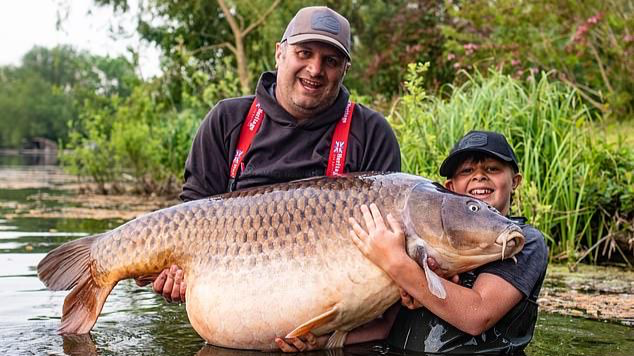 Cậu bé Callum Pettit và bố Stuart bên con cá chép nặng tới 43,5 kg.