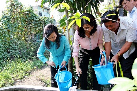 Bộ trưởng Nguyễn Thị Kim Tiến (ngoài cùng bên trái) thả cá diệt lăng quăng.