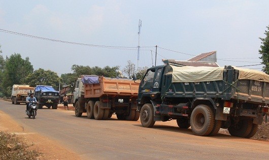 Xe tải chở cát đá để vung vãi ra đường chạy nối đuôi nhau.