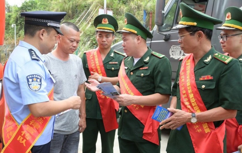 Lực lượng chức năng hai bên tuyên truyền pháp luật cho lái xe hàng qua lại cửa khẩu ( Ảnh: Báo Lạng Sơn)