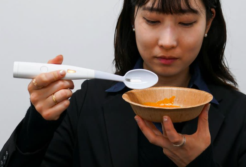 Nhân viên của Kirin trải nghiệm thìa điện tử tạo vị mặn. Ảnh: Kirin