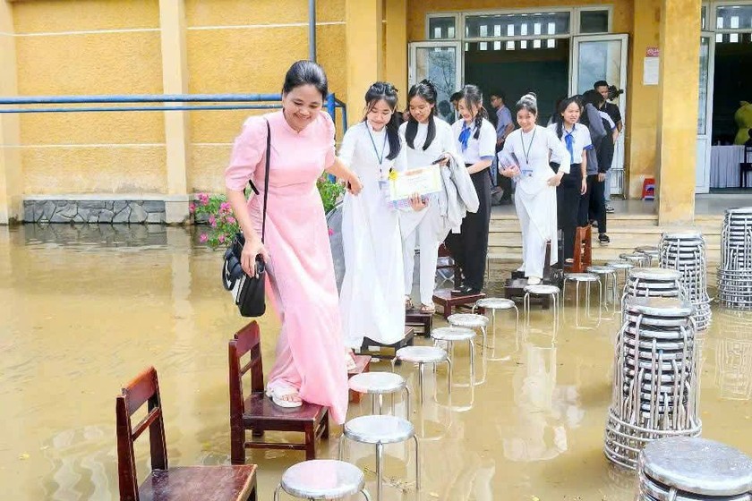 Hình ảnh các em học sinh mặc áo dài, đồng phục chỉnh tề, cẩn thận qua “cây cầu ghế” khiến nhiều người chứng kiến không khỏi xúc động.