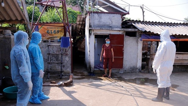 Nhân viên y tế hướng dẫn người dân tại vùng cách ly y tế tự theo dõi sức khoẻ.