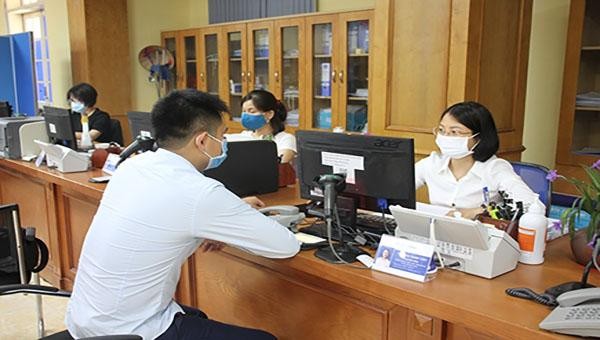 Cán bộ Sở Xây dựng Vĩnh Phúc hướng dẫn người dân về các thủ tục hành chính lĩnh vực xây dựng tại Trung tâm Phục vụ hành chính công tỉnh. Ảnh: Bích Huệ