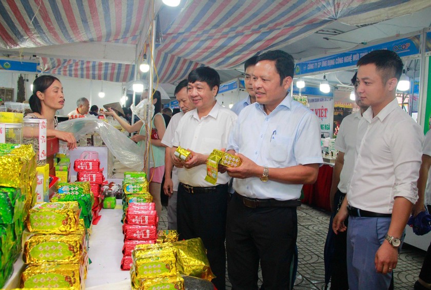 Phó Giám đốc Sở NN&PTNT Hà Nội Tạ Văn Tường, Phó Chánh Văn phòng thường trực Văn phòng Điều phối Nông thôn mới Hà Nội Nguyễn Văn Chí cùng các đại biểu tham quan gian hàng tại chương trình. 