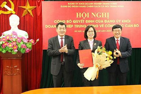 Đồng chí Nguyễn Đức Phong (bên trái) - Phó Bí thư Thường trực Đảng ủy Khối Doanh nghiệp Trung ương và đồng chí Dương Quyết Thắng (bên phải) - Bí thư Đảng ủy NHCSXHTW, Tổng Giám đốc trao Quyết định và chúc mừng đồng chí Lê Thị Đức Hạnh. (Ảnh: VBSP)