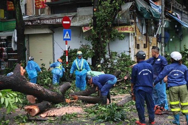 Lực lượng chức năng khắc phục hậu quả tại phố Đinh Tiên Hoàng, quận Hoàn Kiếm. (Nguồn: TTXVN)