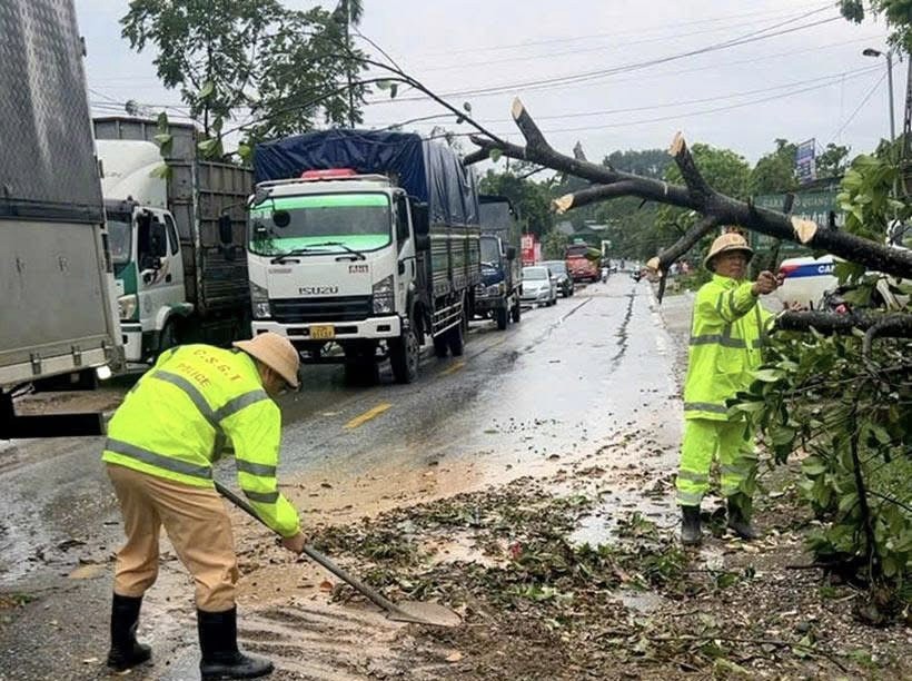 Lực lượng Cảnh sát giao thông (Công an tỉnh Tuyên Quang) hỗ trợ người dân khắc phục cây đổ tại Hàm Yên.