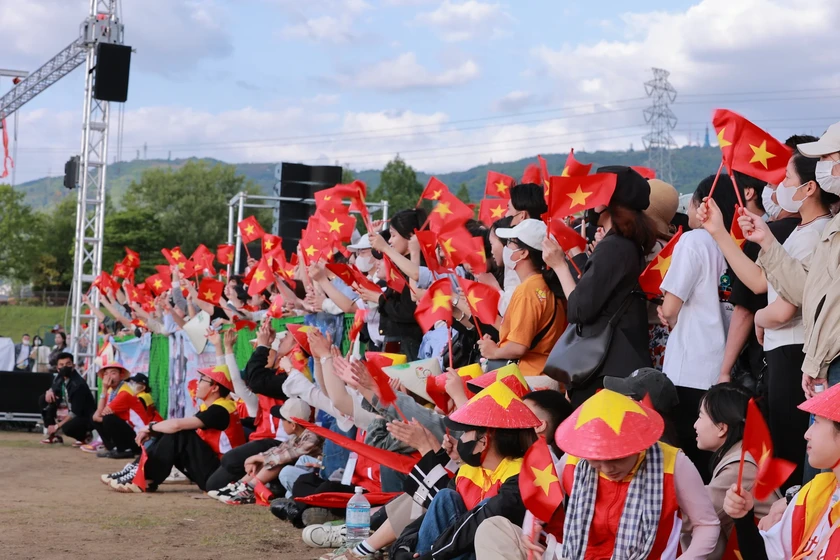 Người dân Việt Nam tại Nhật Bản hào hứng tham gia Festival “Trái tim Việt Nam - 50 năm hòa chung một nhịp” với nón và lá cờ đỏ sao vàng. (ảnh BTC)