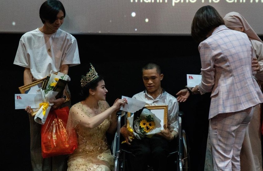 Các nhà hảo tâm, người tham dự chương trình tặng quà cho hai em học sinh nhận học bổng Tiếp sức đến trường.  