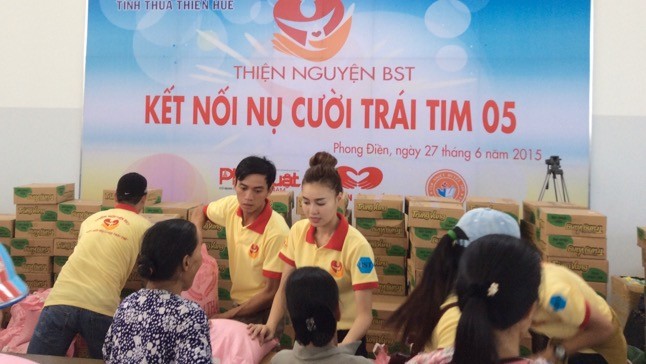 Các thiện nguyện viên trao quà cho bà con